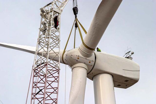 Workers assemble a wind turbine for a heavy construction project.